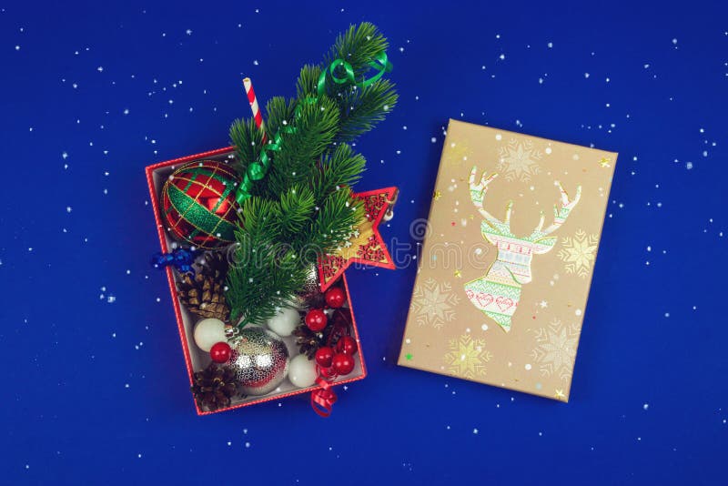 Contenitore di regalo aperto della composizione di natale con i cervi e i regali in fondo e neve blu fotografia stock libera da diritti