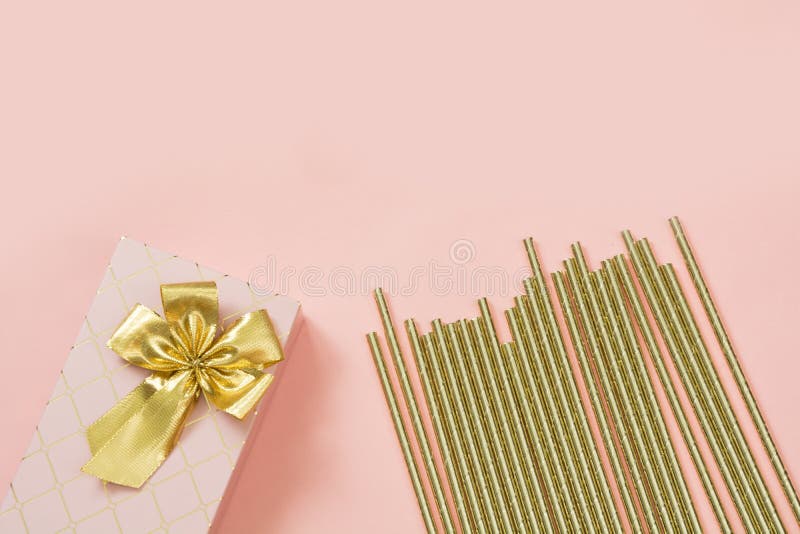 Contenitore di regalo femminile con gli accessori dorati del cocktail e del nastro sul rosa pastello punchy Copi lo spazio immagine stock Contenitore di regalo femminile con gli accessori dorati del cocktail e del nastro sul rosa pastello punchy Copi lo spazio immagine stock