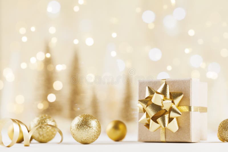 Contenitore di regalo di Natale contro il fondo dorato del bokeh Cartolina d'auguri di festa
