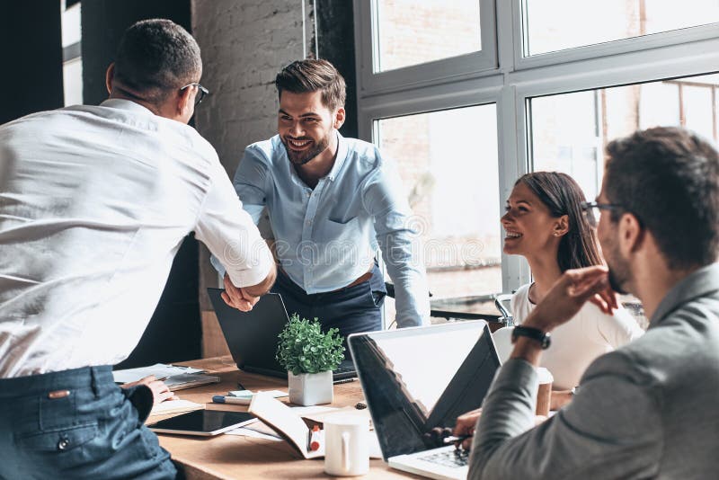 Contente de trabalhar com você! Homens modernos novos no sha esperto do vestuário desportivo imagem de stock Contente de trabalhar com você! Homens modernos novos no sha esperto do vestuário desportivo imagem de stock