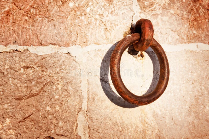 Contexto de la pared de piedra y del anillo oxidado foto de archivo Contexto de la pared de piedra y del anillo oxidado foto de archivo