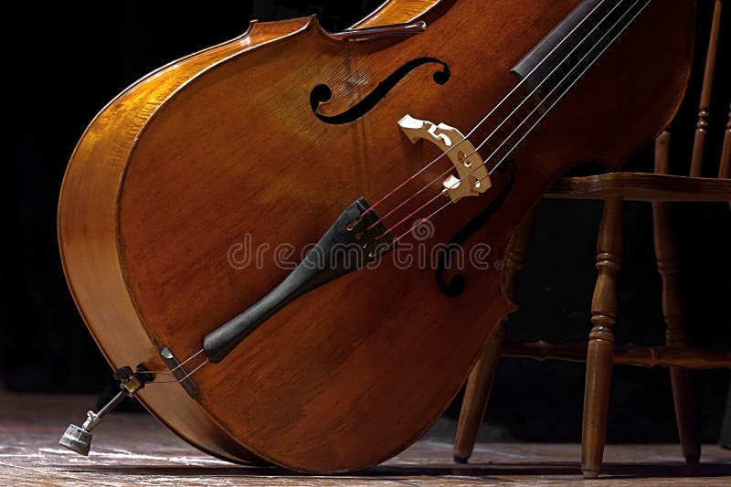 Contrabajo colocado en una posición oblicua que espera para ser utilizado en un concierto de la música clásica evocador de los di imagenes de archivo Contrabajo colocado en una posición oblicua que espera para ser utilizado en un concierto de la música clásica evocador de los di imagenes de archivo