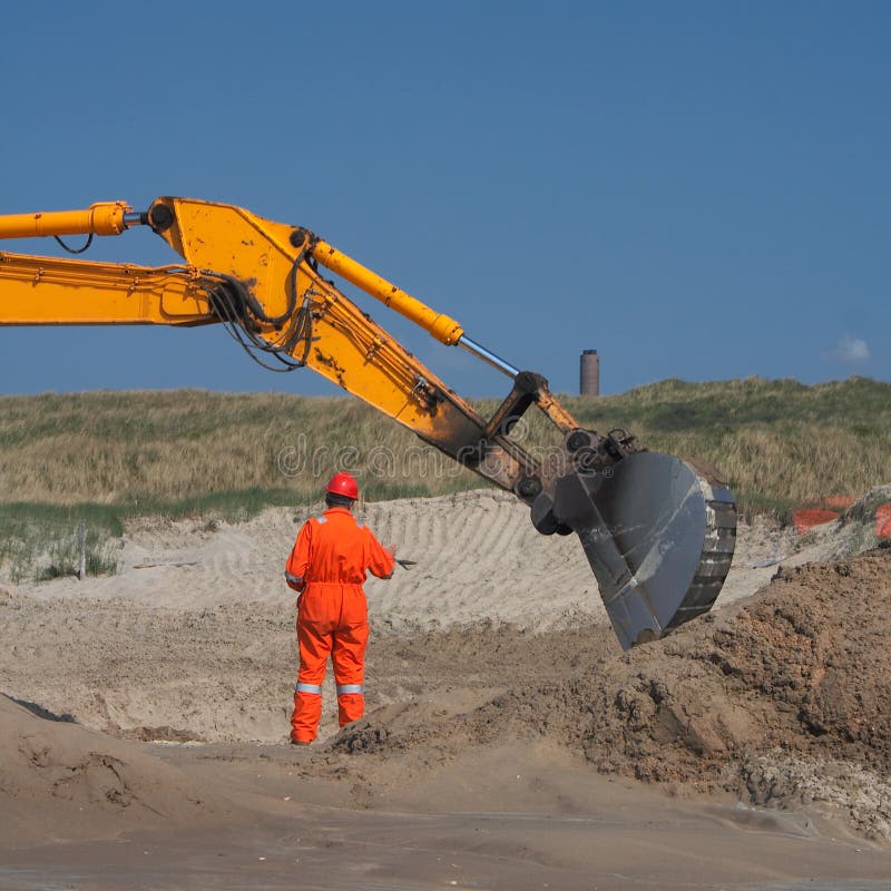 A Contractor walking to a earth mover/digger.