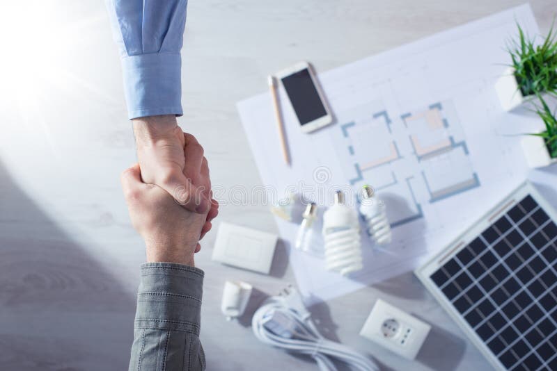 Contractor and customer shaking hands stock photos