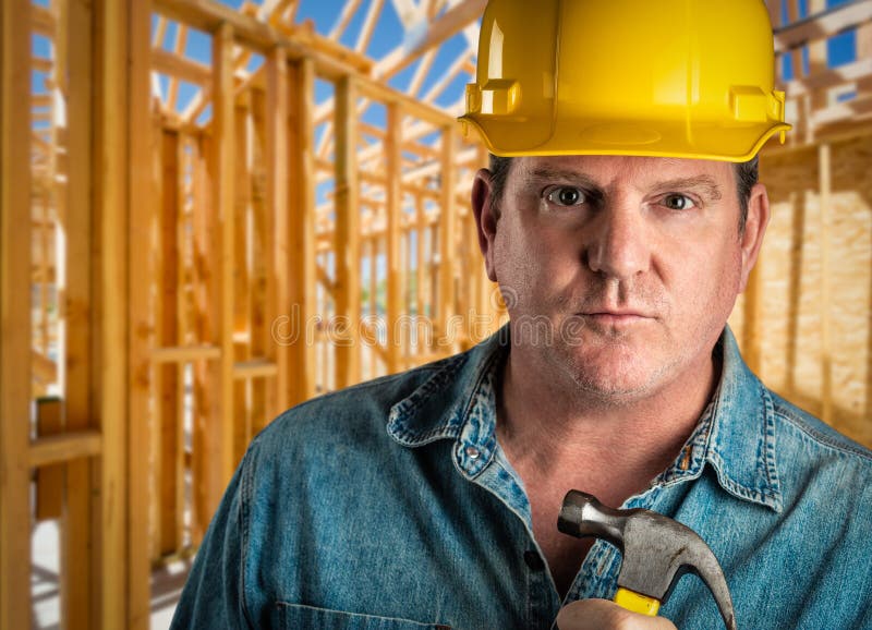 Contractor in Hard Hat Holding Hammer at Construction Site Stock Image