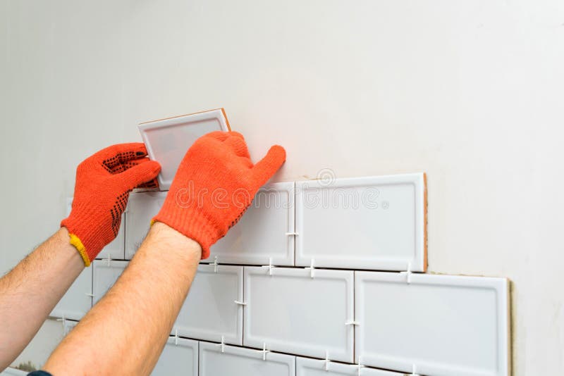 Contractor is Tiling the White Tiles on the Kitchen Wall. Concept of a