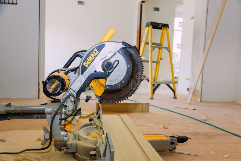 Contractor using DeWalt circular saw cutting base moulding for Renovation