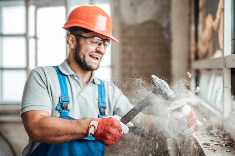 Contractor, working very hard, strikes with a hammer, screaming