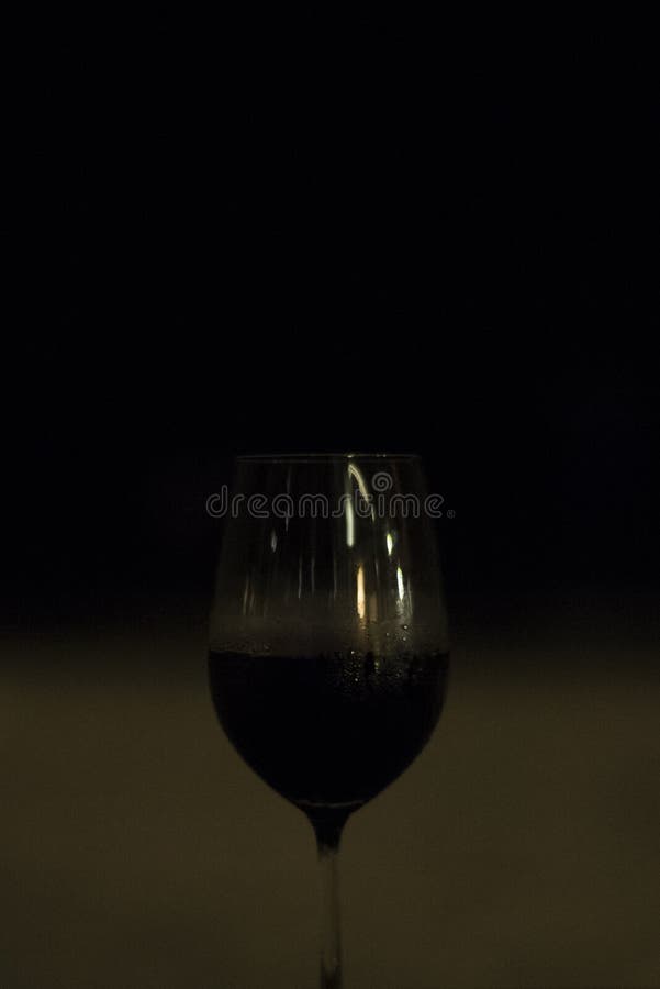 Contrast of a Red Wine Glass on a Beach at Night. Stock Image Image