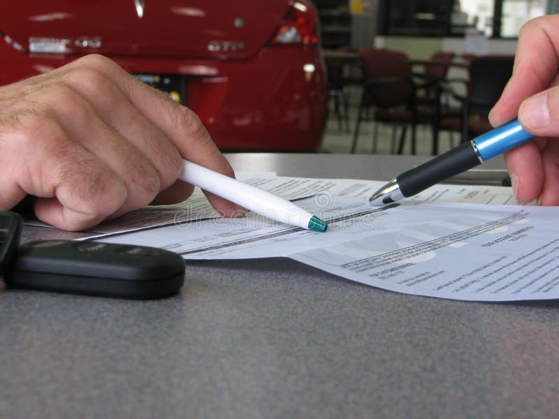 Close-up of two male hands showing an stipulation in a contract. car dealer/blur background. Close-up of two male hands showing an stipulation in a contract. car dealer/blur background.