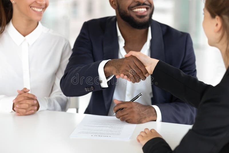 Contratto misto felice di ipoteca del segno del mediatore di handshake delle coppie di etnia immagine stock libera da diritti Contratto misto felice di ipoteca del segno del mediatore di handshake delle coppie di etnia immagine stock libera da diritti
