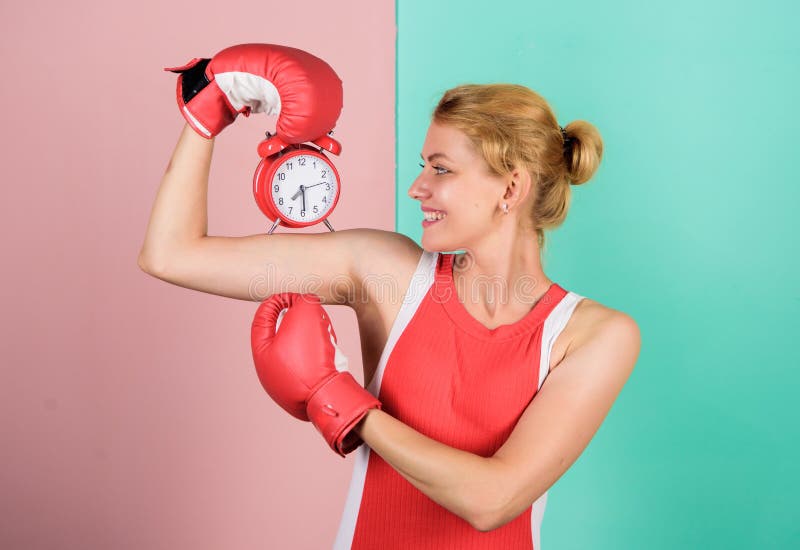 Control time. Punctuality and personal efficiency. Time management skills. Battle for self discipline. Woman holding clock boxing gloves. Boxer fighting with alarm clock. Time for boxing training.