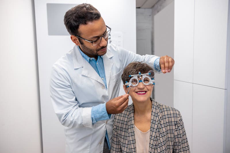 Controllo dell'optometrista maschile alla vista di una visitatrice fotografie stock libere da diritti