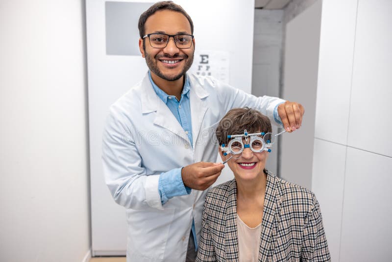Controllo dell'optometrista maschile alla vista di una visitatrice immagini stock
