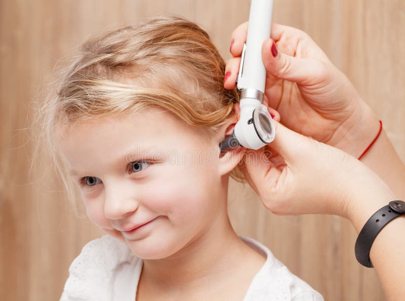 Contrôle OTO-RHINO d'enfant - oreille de examen de docteur d'une petite fille avec l'oto