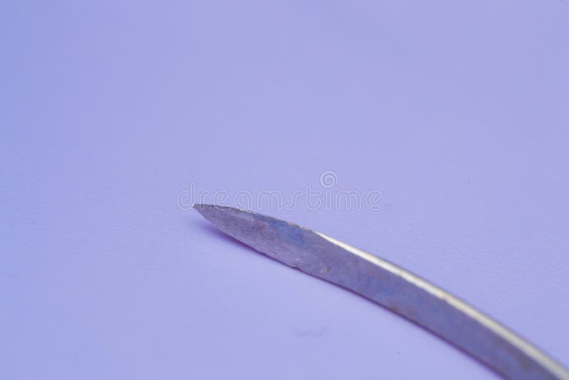 Conventional Cutting Needle Used in Surgery on Blue Background Stock