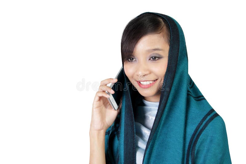 Conversa muçulmana de sorriso da menina no telefone fotos de stock Conversa muçulmana de sorriso da menina no telefone fotos de stock