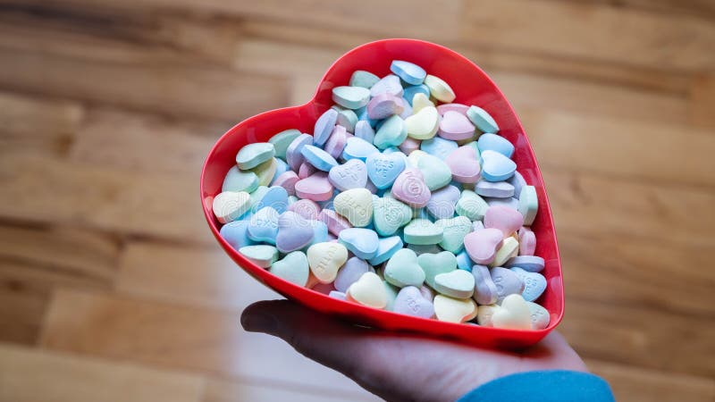 Conversación de dulces pasteles en un tazón con forma de corazón rojo. imagen de archivo