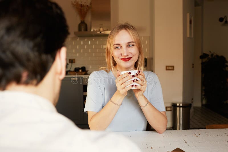 Conversation of confident man and young blond woman at home royalty free stock image Conversation of confident man and young blond woman at home royalty free stock image