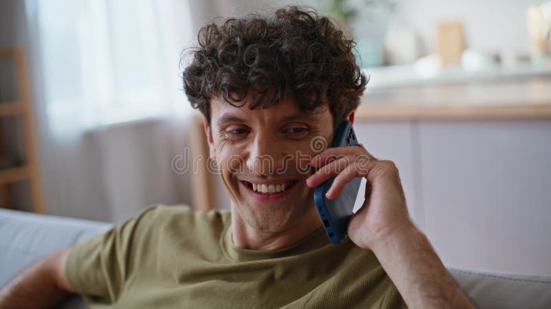 Conversation téléphonique d'homme positif sur canapé à la maison de week-end se sentir détendu closeup photos libres de droits