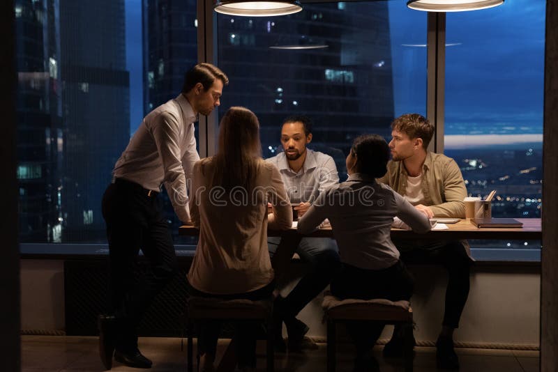 Conversazione di un team di business ispirato fino a tarda sera per parlare di startup