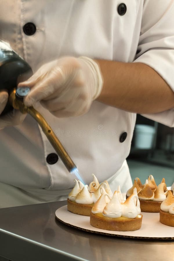 Cook Browning the Meringue with a Burning Iron Stock Photo Image of