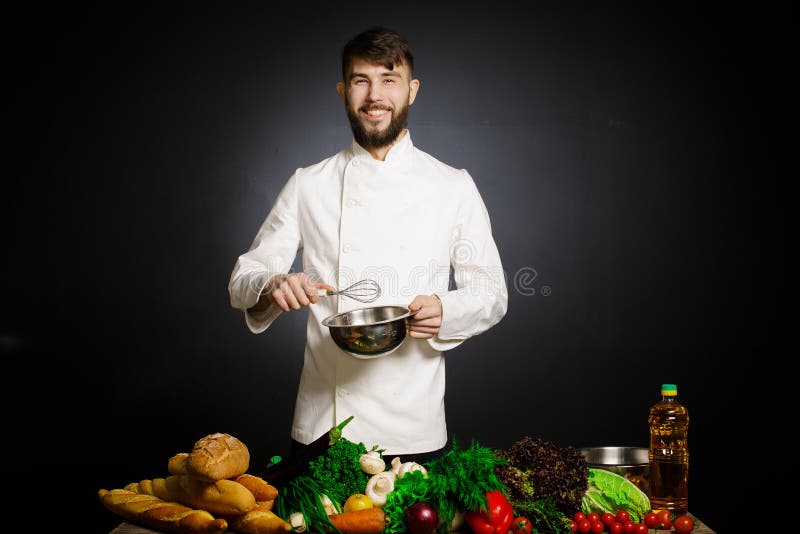 Cook chef with vegetables splah and black dark background. Food musical harmony. Chef juggling with vegetables and other food in t stock photos Cook chef with vegetables splah and black dark background. Food musical harmony. Chef juggling with vegetables and other food in t stock photos