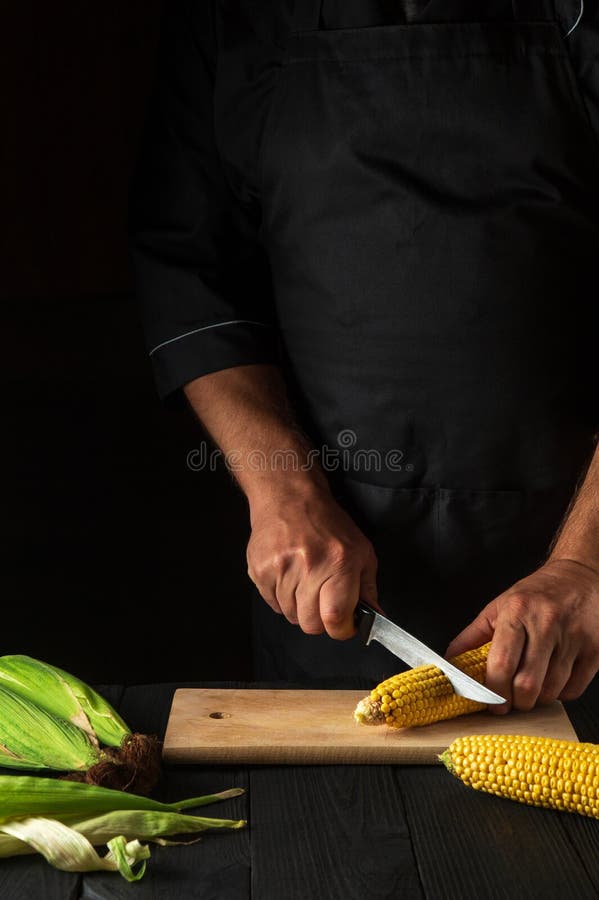 The Cook Cuts Fresh Corn with a Knife. Boiled Corn is a Great Diet for