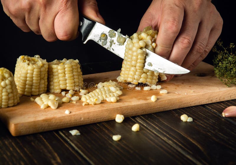 The Cook Cuts the Grains of Boiled Corn with a Knife. Maize is an