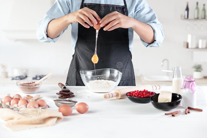 A cook with eggs on a rustic kitchen against the background of men`s hands royalty free stock photography A cook with eggs on a rustic kitchen against the background of men`s hands royalty free stock photography