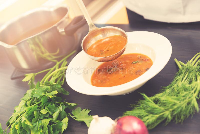 Pouring Soup In A Plate On Served Table With A Ladle Stock Photo