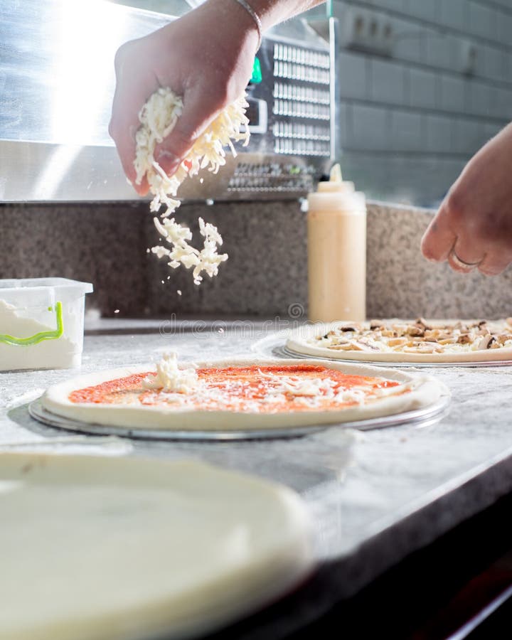 Cook Sprinkles the Cheese on the Pizza. Stock Image Image of dough