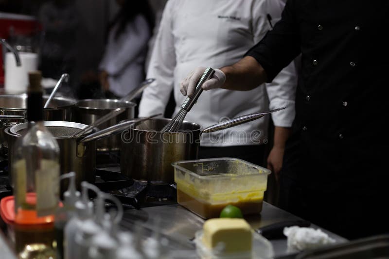 A Cook Stirring Pots in the Kitchen. Big Pots in the Kitchen Stock