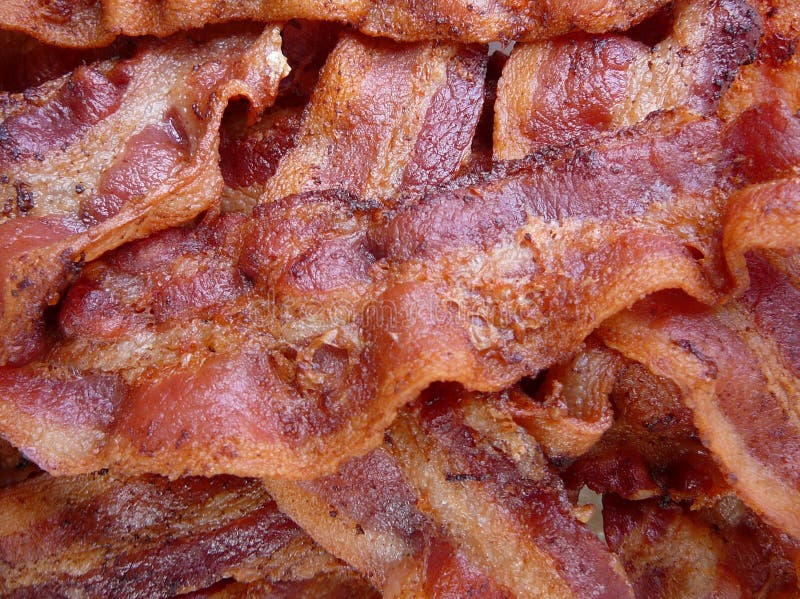 Cooked Bacon. Crisp cooked bacon in a pile Cooked Bacon. Crisp cooked bacon in a pile