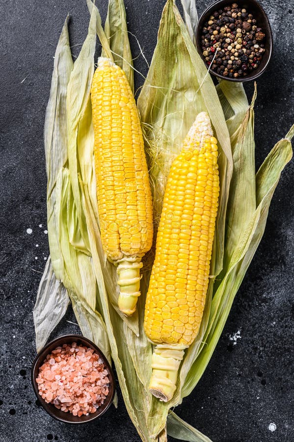 Cooked Corn on Cobs with Salt and Pepper. Black Background Stock Image