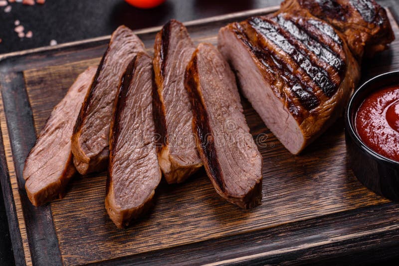 Cooked Grilled Chuck Eye Roll Steak on a Chopping Board Stock Photo