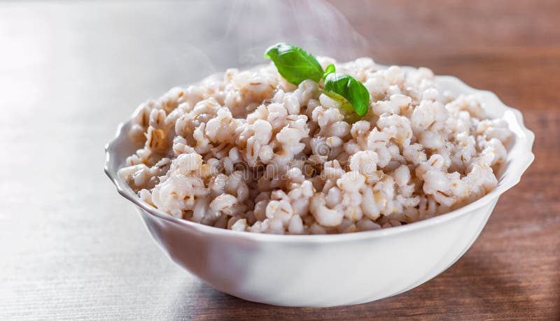 Cooked pearl barley in bowl on a wooden table royalty free stock photo Cooked pearl barley in bowl on a wooden table royalty free stock photo