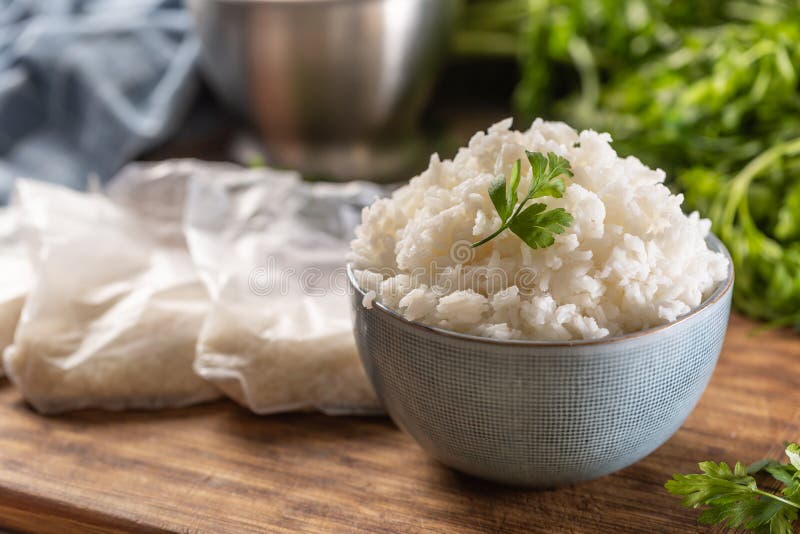 Cooked Rice in a Bowl with Raw Rice in Plastick Bags Stock Image