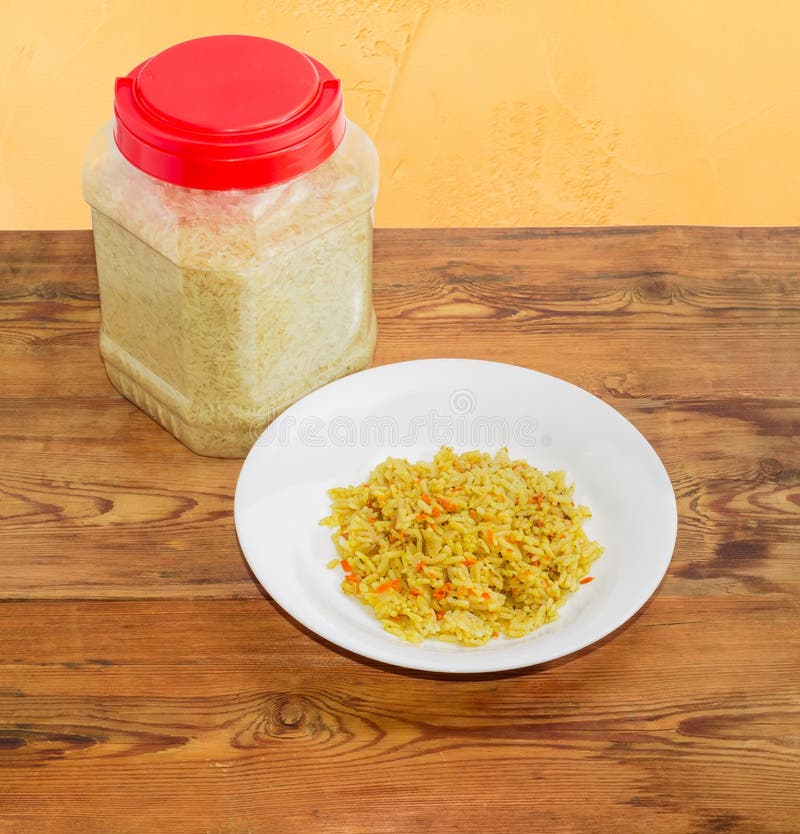 Cooked Rice on Dish and Uncooked Rice in Plastic Container Stock Image