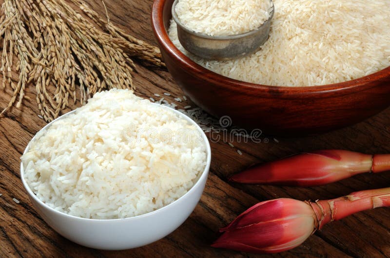 Cooked Rice, Uncooked Rice and Paddy Rice on Wooden Table Stock Image