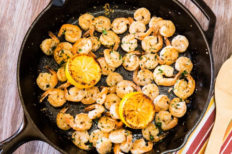 Cooked Shrimp Meal With Lemon In Cast Iron Skillet