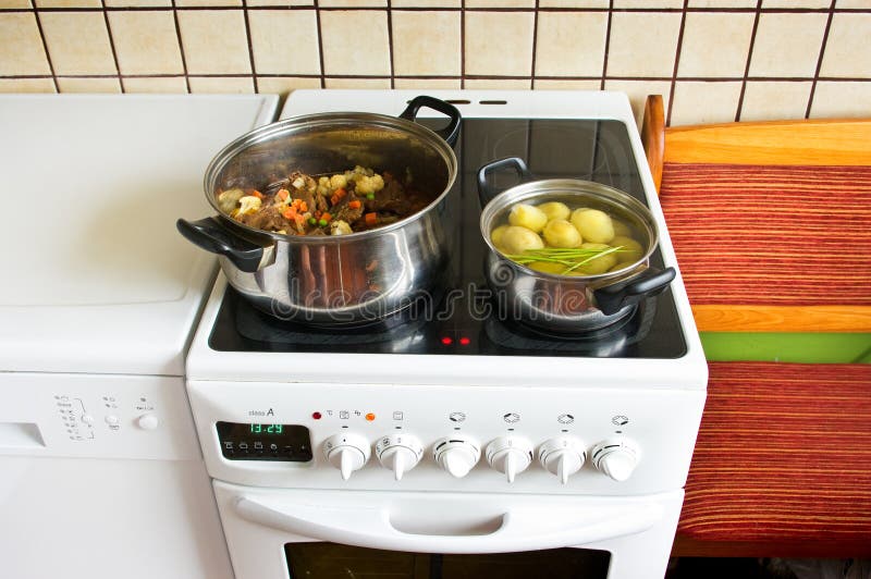 Cooker during the dinner preparation stock images