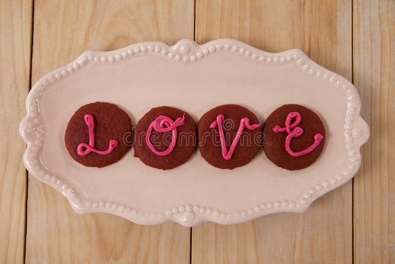 Cookies congeladas com amor de indicação de creme cor-de-rosa imagem de stock Cookies congeladas com amor de indicação de creme cor-de-rosa imagem de stock