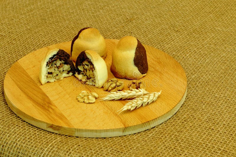 Cookies de biscoito amanteigado caseiros deliciosas enchidas com as nozes, os spikelets do trigo e as porcas na placa de madeira fotos de stock Cookies de biscoito amanteigado caseiros deliciosas enchidas com as nozes, os spikelets do trigo e as porcas na placa de madeira fotos de stock