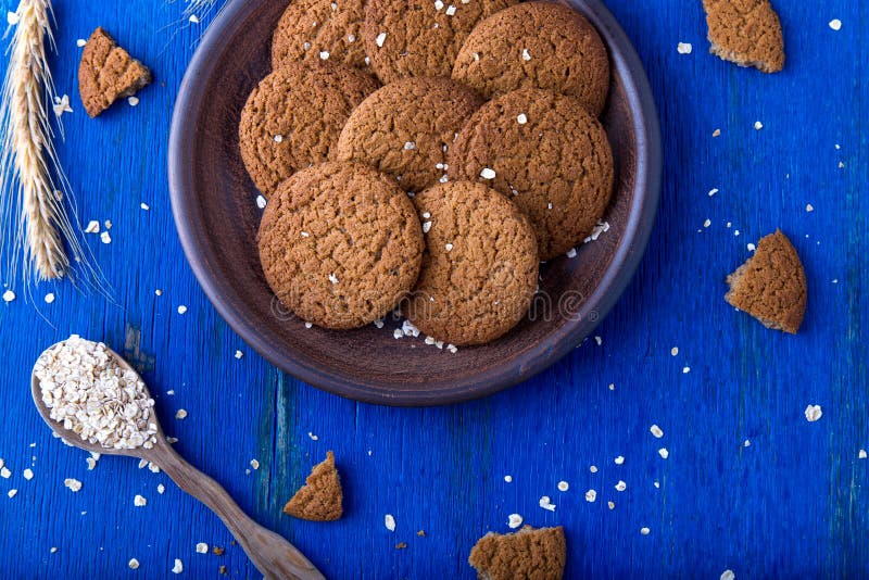 Cookies de farinha de aveia na placa marrom no fundo azul Estilo rústico Vista superior imagem de stock royalty free Cookies de farinha de aveia na placa marrom no fundo azul Estilo rústico Vista superior imagem de stock royalty free