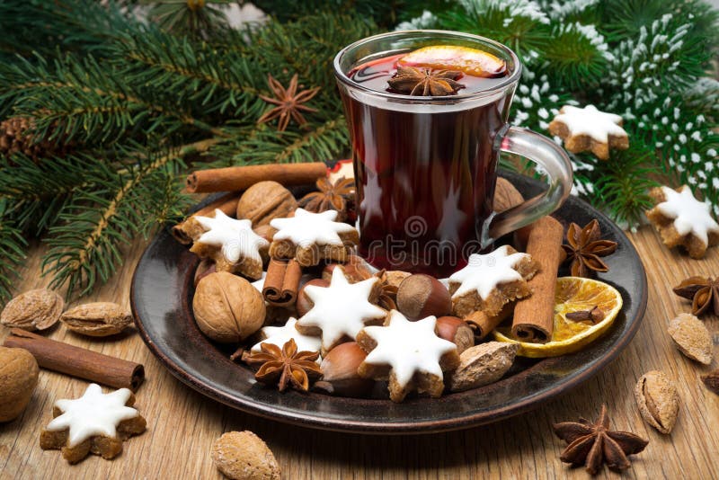 Cookies in the shape of stars, spices and mulled wine on a plate