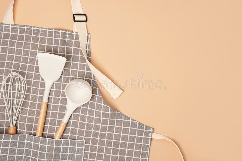 Premium Photo  Kitchen beige apron wooden spoon with spices pepper mill  wood kitchen utensils on a wooden background top view
