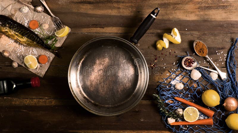 Cooking background. Smoked fish with spices and lemon on a wooden background. Maritime style, a blue fishing net and shells, top