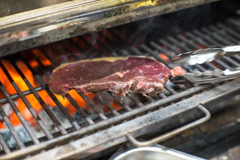 Cooking Beef Steak on a Barbecue Grill. Restaurant, Chef. Open Fire
