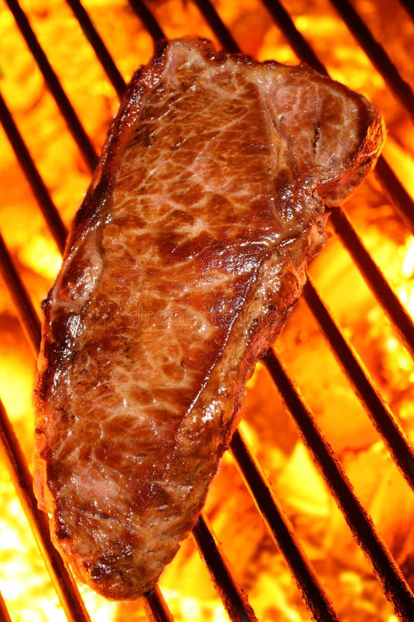 Bistecca di manzo su un barbecue sul fuoco carboni.